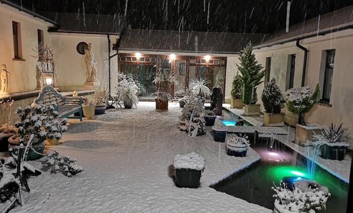 Snow in the courtyard; inner pond with coloured lights, all other lights on